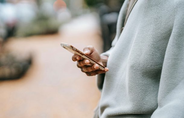 Guy in a grey sweater on their iPhone