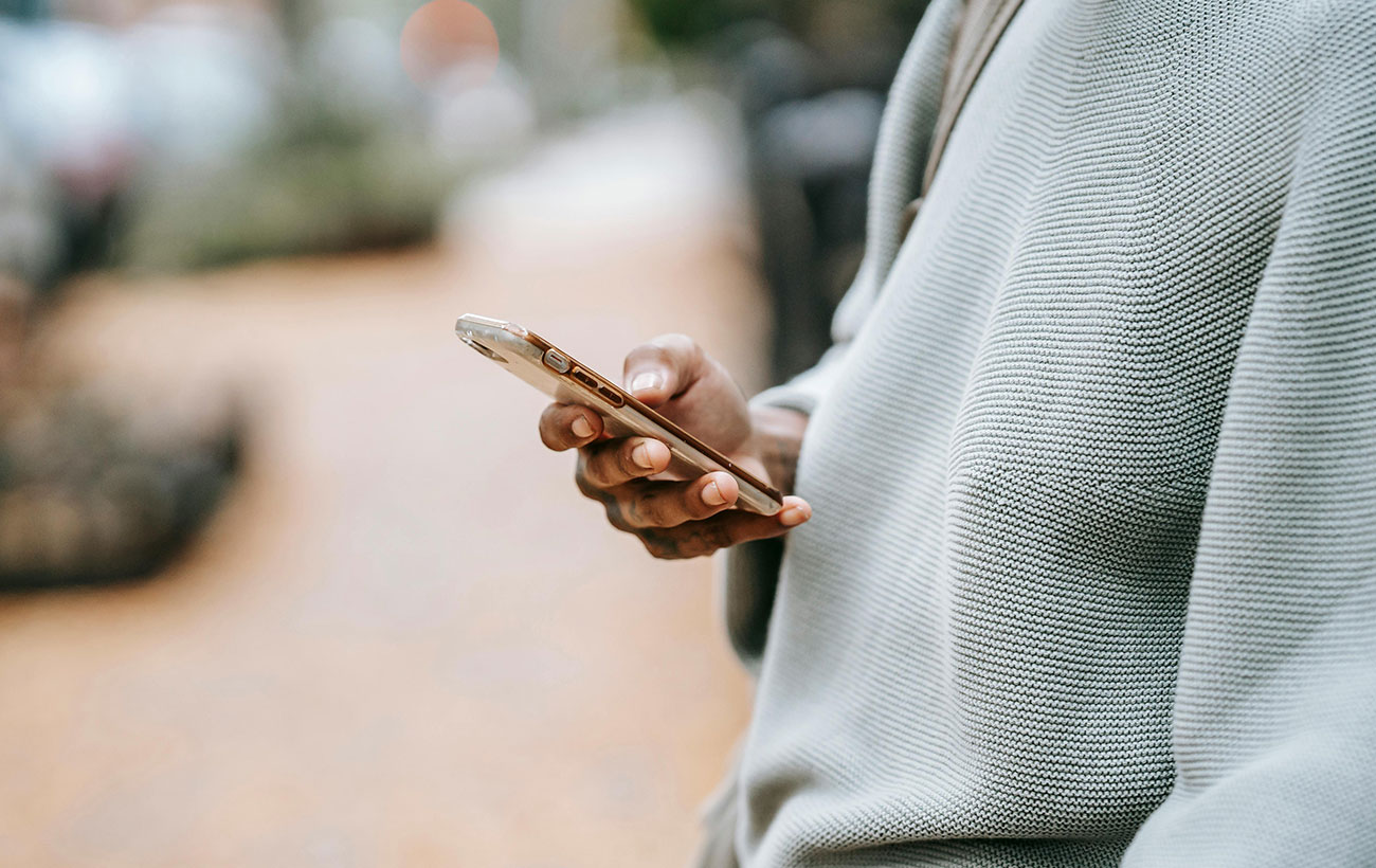 Guy in a grey sweater on their iPhone